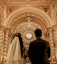 Bride and groom standing together inside an ornate church during their wedding ceremony