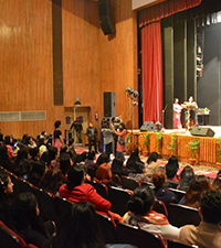 College auditorium filled with an audience watching a formal stage presentation and event