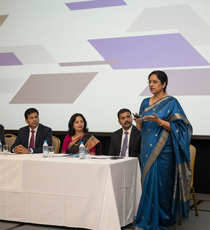 Photographer capturing a speaker and guests during a formal corporate event in Coimbatore